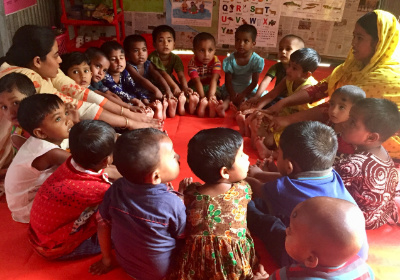 Childcare center with kids and teachers in circle